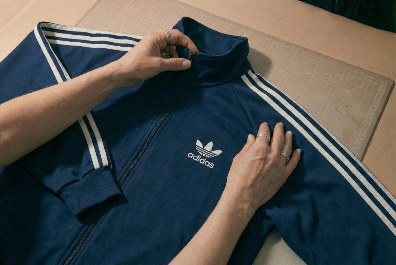 Adidas-Jacke wird auf dem Tisch geprüft